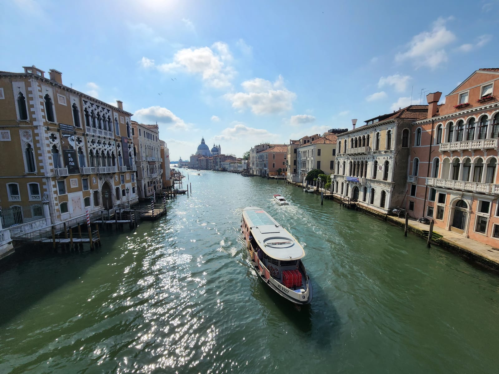 Morning on the Grand Canal in Venice — a vaporetto heading out under a bright sky